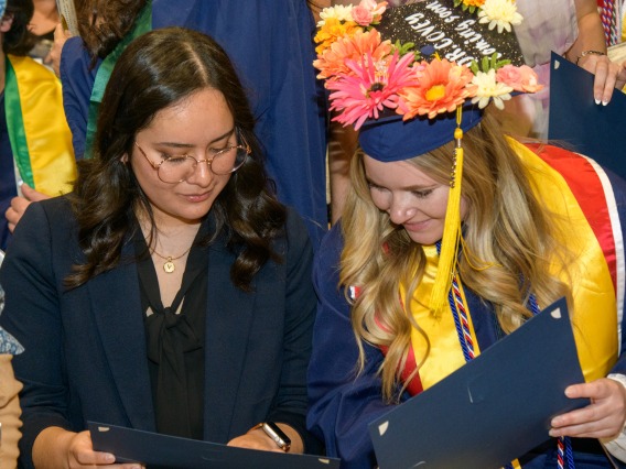 NSCS graduates looking over their diplomas.