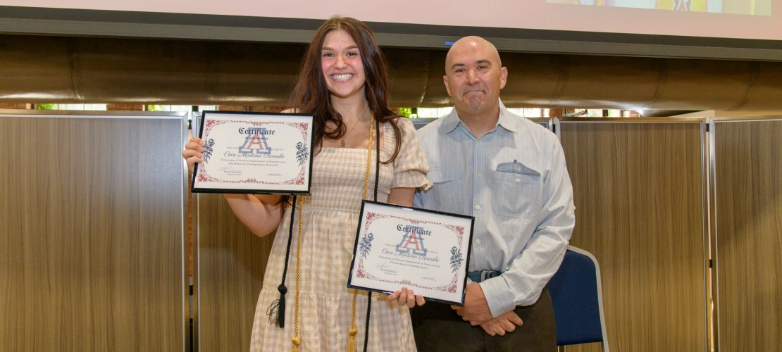 Cecilia Roessle standing with Dr. Ricoy, displaying Outstanding Senior Award and Diploma.