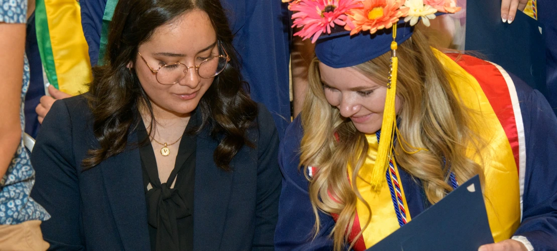 NSCS graduates looking over their diplomas.